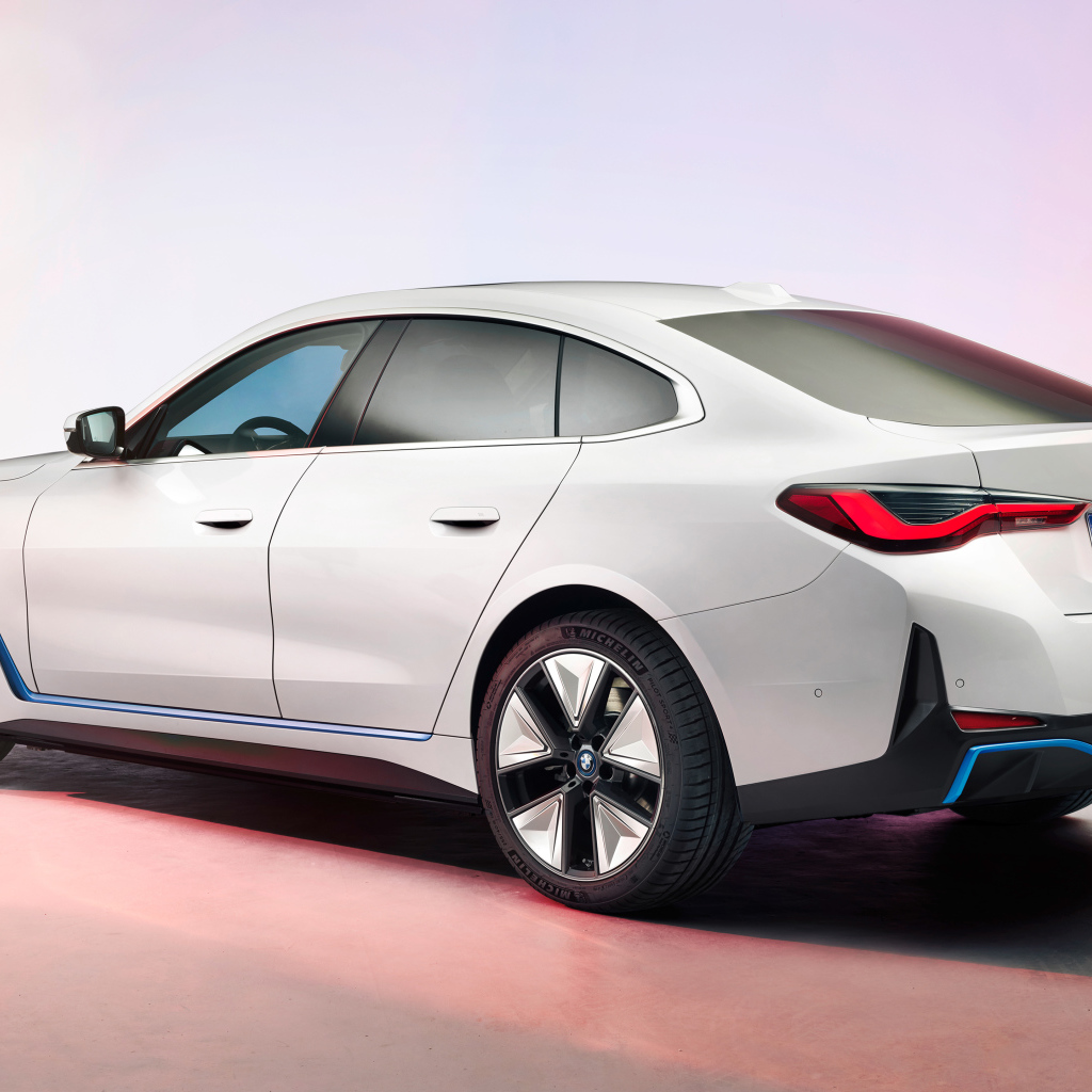 Белый автомобиль BMW I4 2021 года на розовом фоне