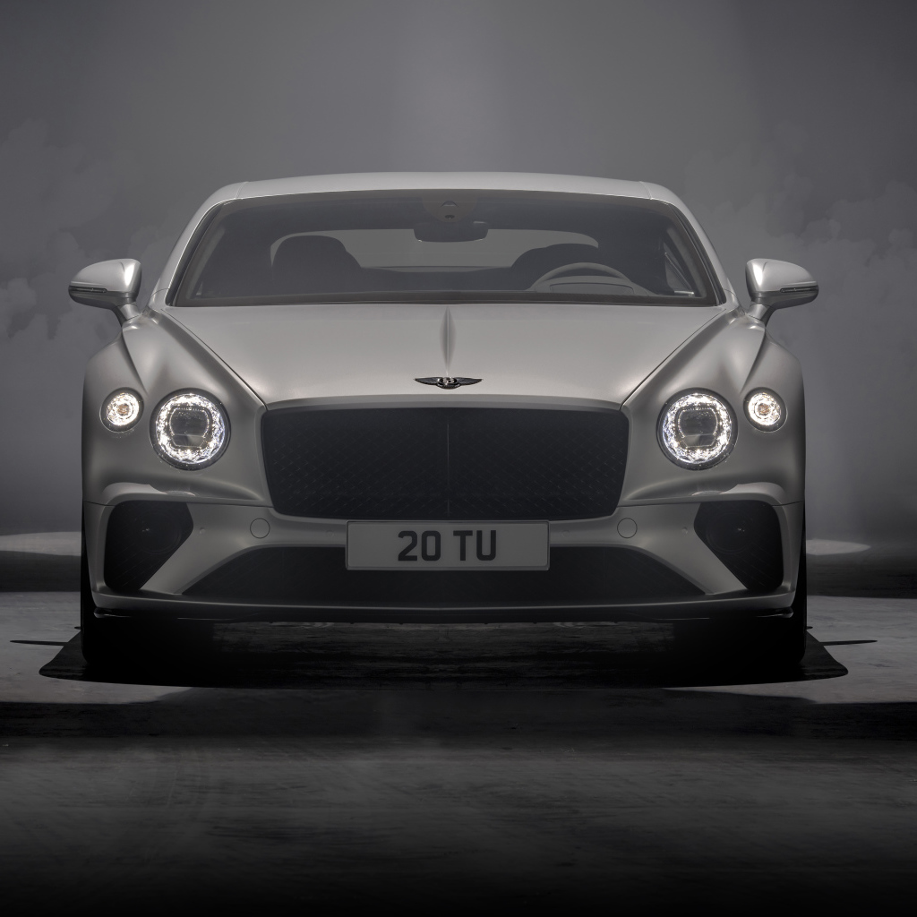 Серебристый автомобиль Bentley Continental GT Speed 2021 года на сером фоне