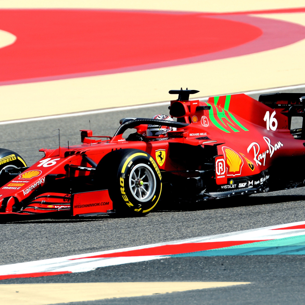 Красный гоночный автомобиль Ferrari SF21 2021 года на трассе