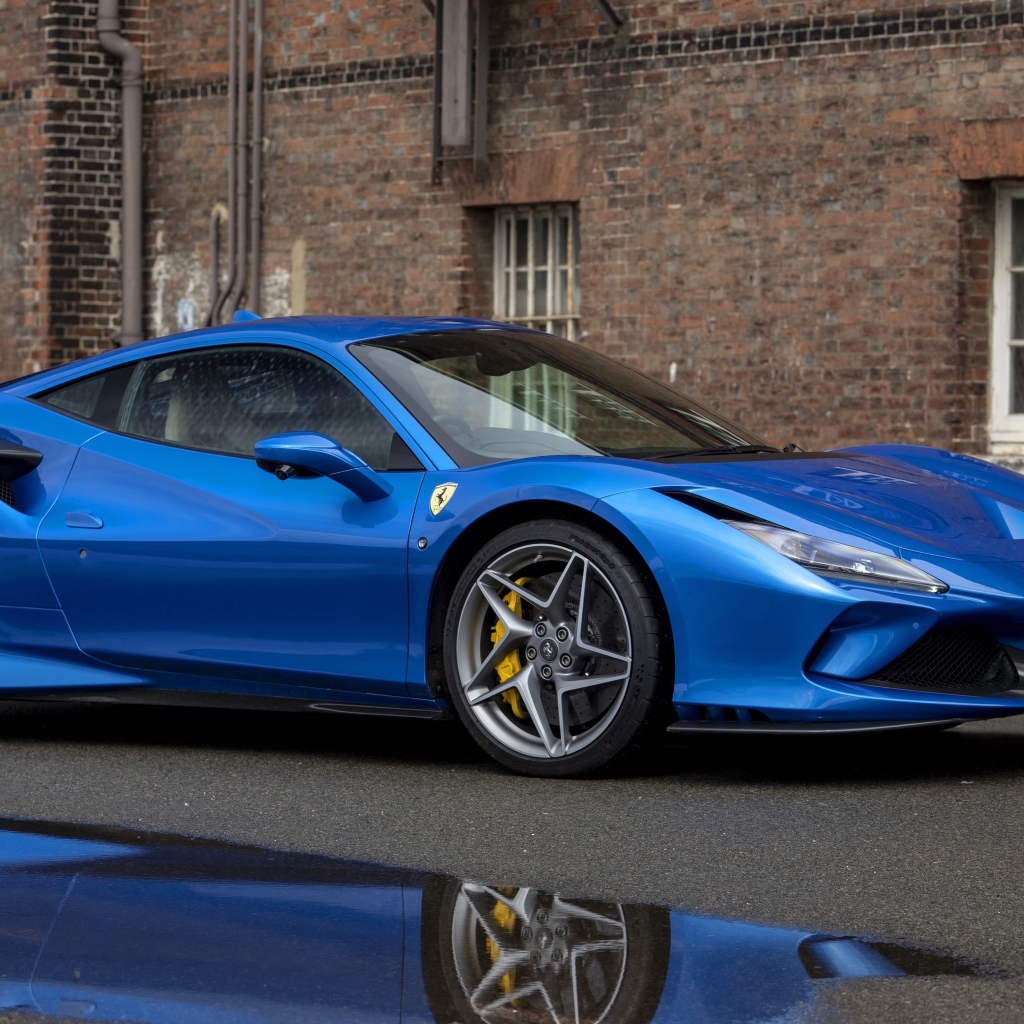 Синий автомобиль Ferrari F8 Tributo у здания