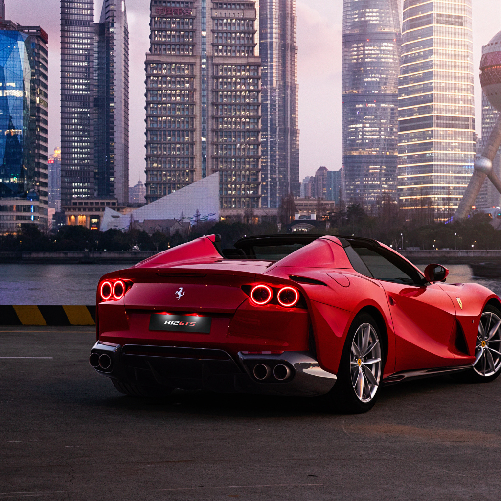 Автомобиль  Ferrari 812 GTS вид сзади на фоне города