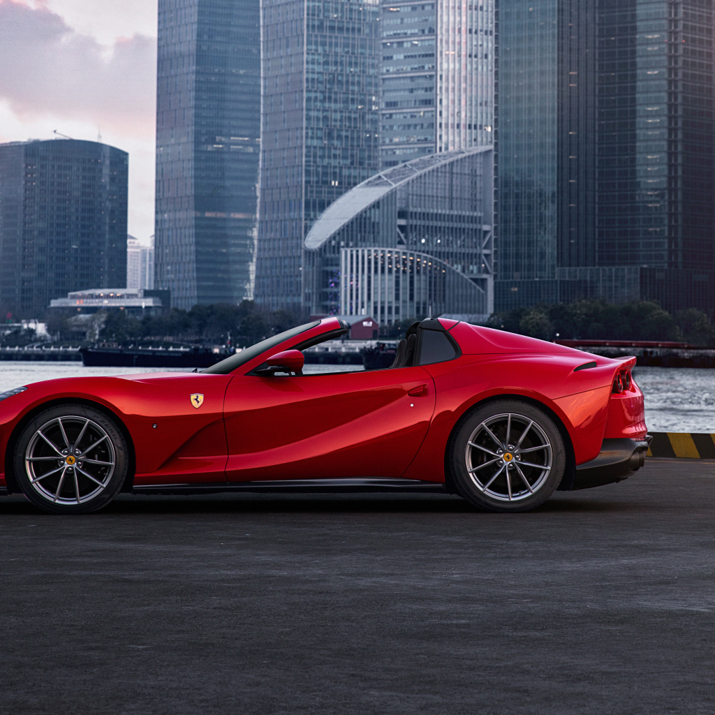 Красный автомобиль  Ferrari 812 GTS на фоне города