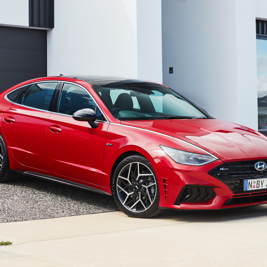 Красный автомобиль Hyundai Sonata N Line 2021 года у гаража