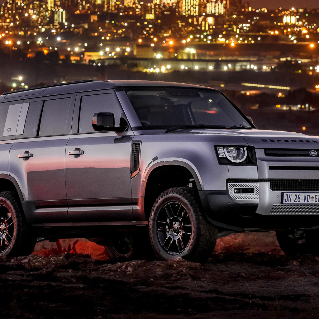 Серебристый внедорожник Land Rover Defender 110 P400 S Urban Pack 2021 года на фоне города