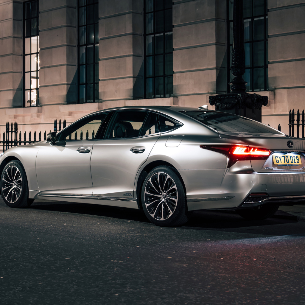 Серебристый автомобиль Lexus LS 500h 2021  года вид сзади