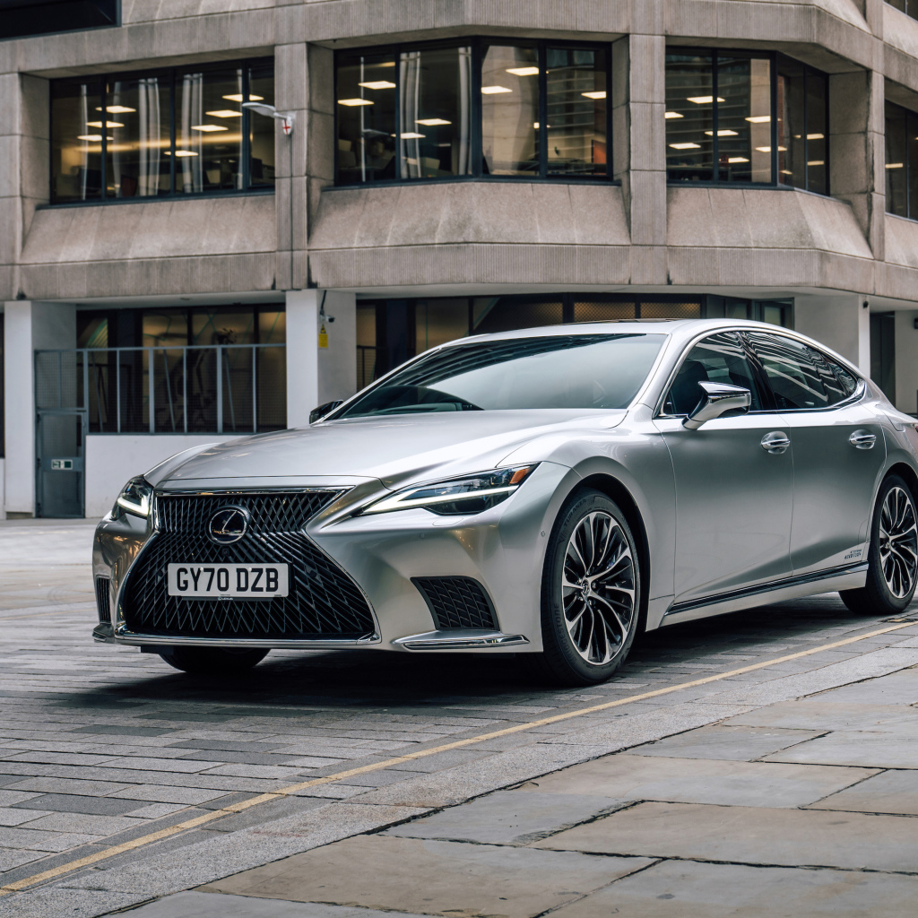 Серебристый автомобиль Lexus LS 500h 2021 года в городе у дома