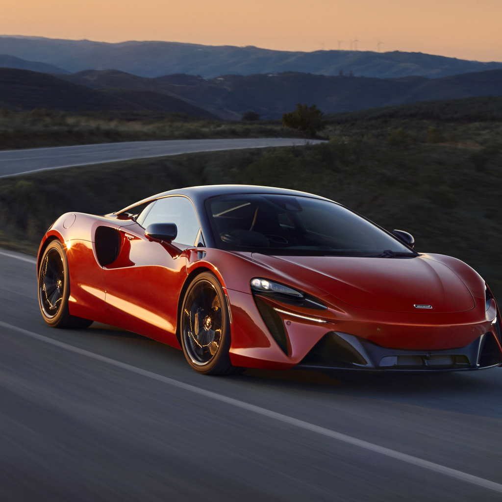 Красный автомобиль McLaren Artura, 2022 года на трассе