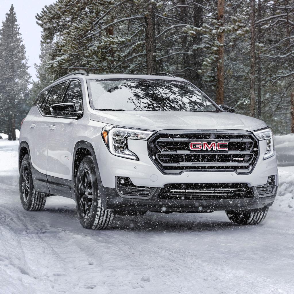 Большой белый внедорожник GMC Terrain AT4, 2022 года на снегу