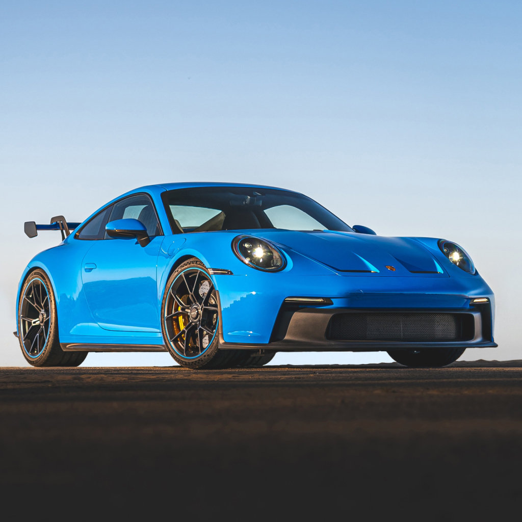 Синий автомобиль Porsche 911 GT3 2021 года на фоне неба