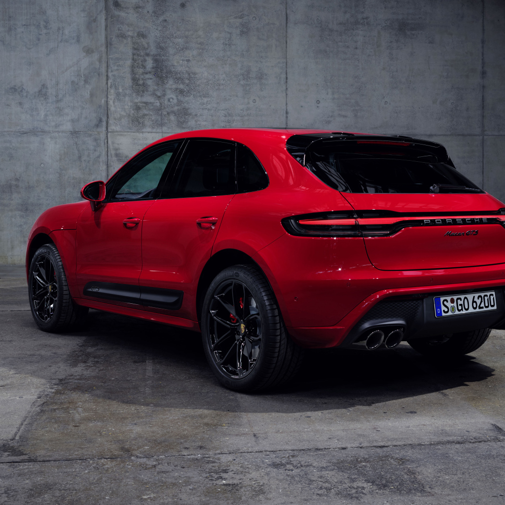 Красный автомобиль Porsche Macan GTS 2021 года на сером фоне вид сзади