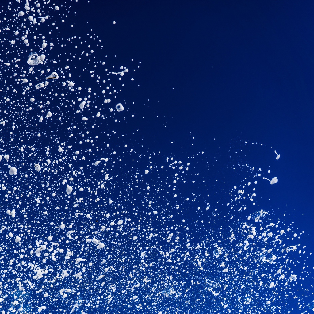 Белые брызги воды на синем фоне 