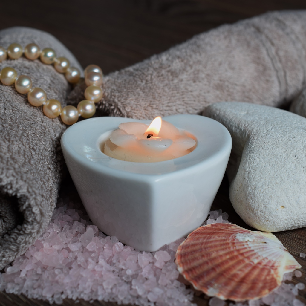 Красивая свеча с полотенцем, бусами, камнями и морской солью