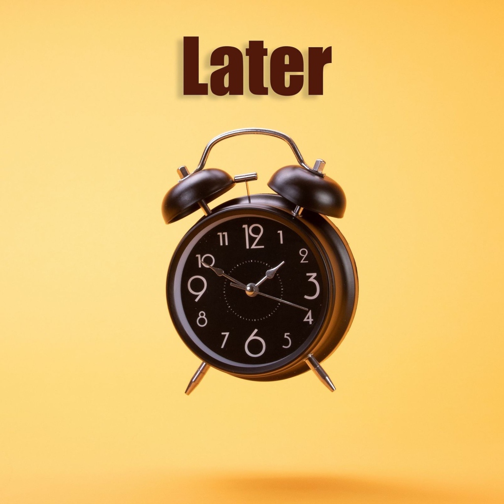 Большой черный будильник на желтом фоне 