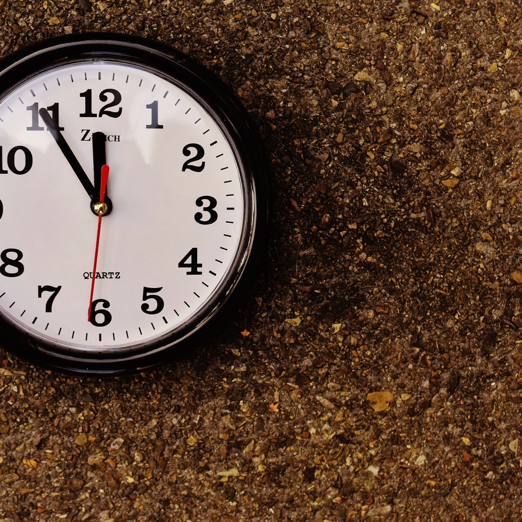 Большие черные часы висят на стене 