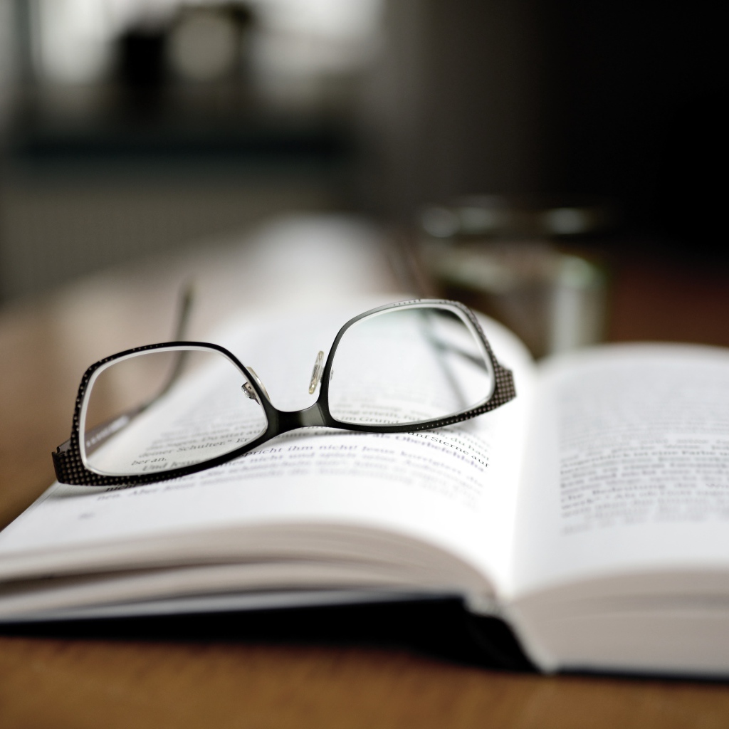 Черные очки лежат на книге 