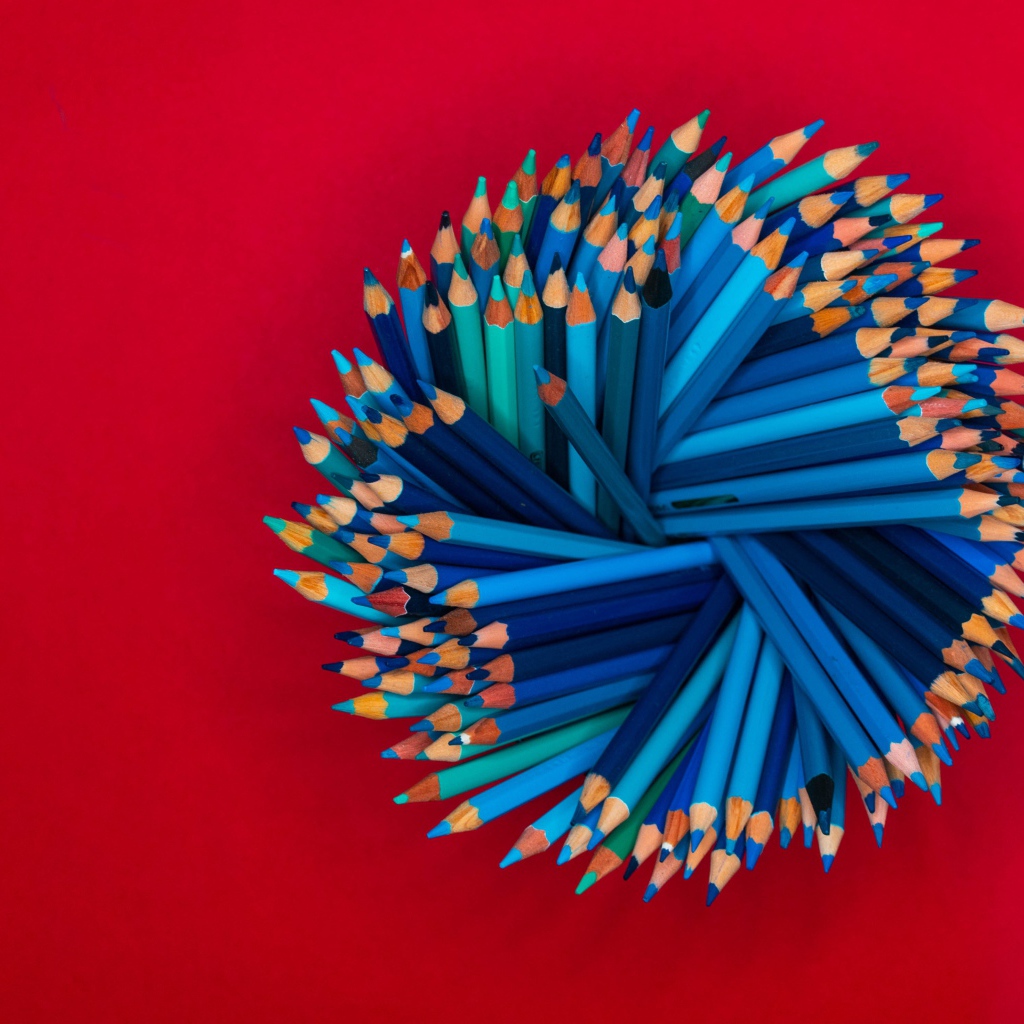 Синие карандаши на красном фоне