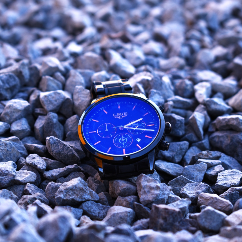 Голубые наручные часы лежат на камнях