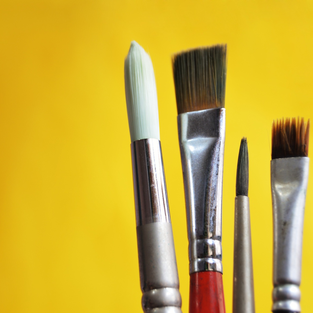Кисти разной величины на желтом фоне