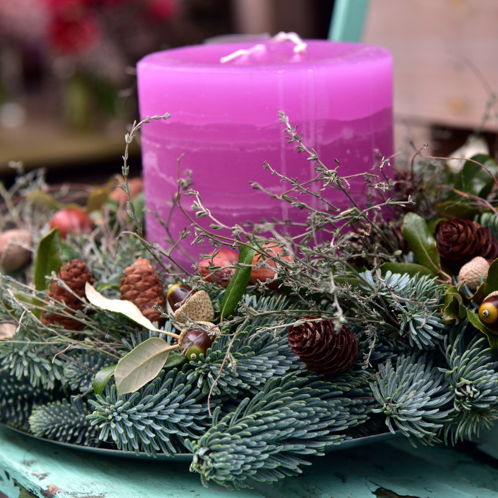 Candle with a wreath on a bench