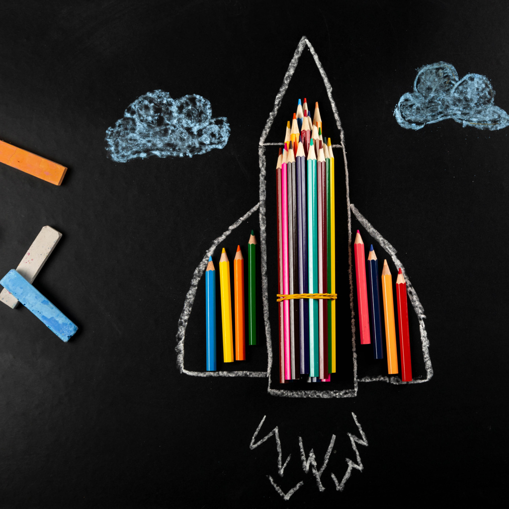 Нарисованная ракета с мелом и карандашами 