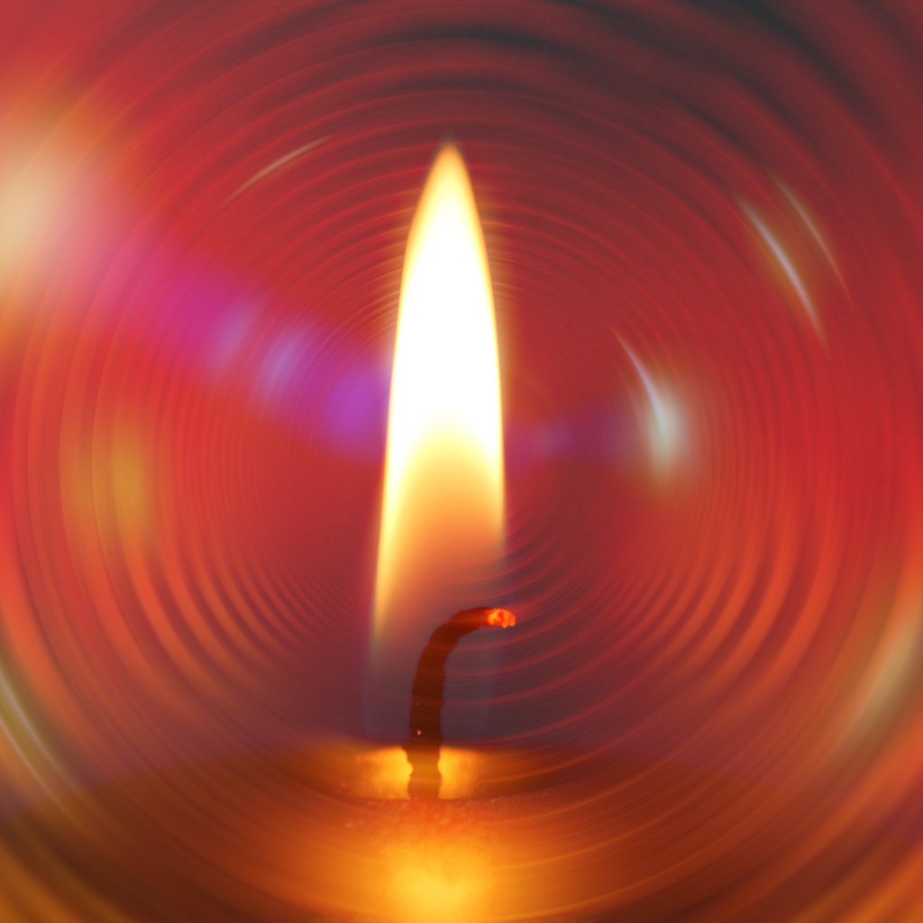Огонь свечи на фоне красного круга 
