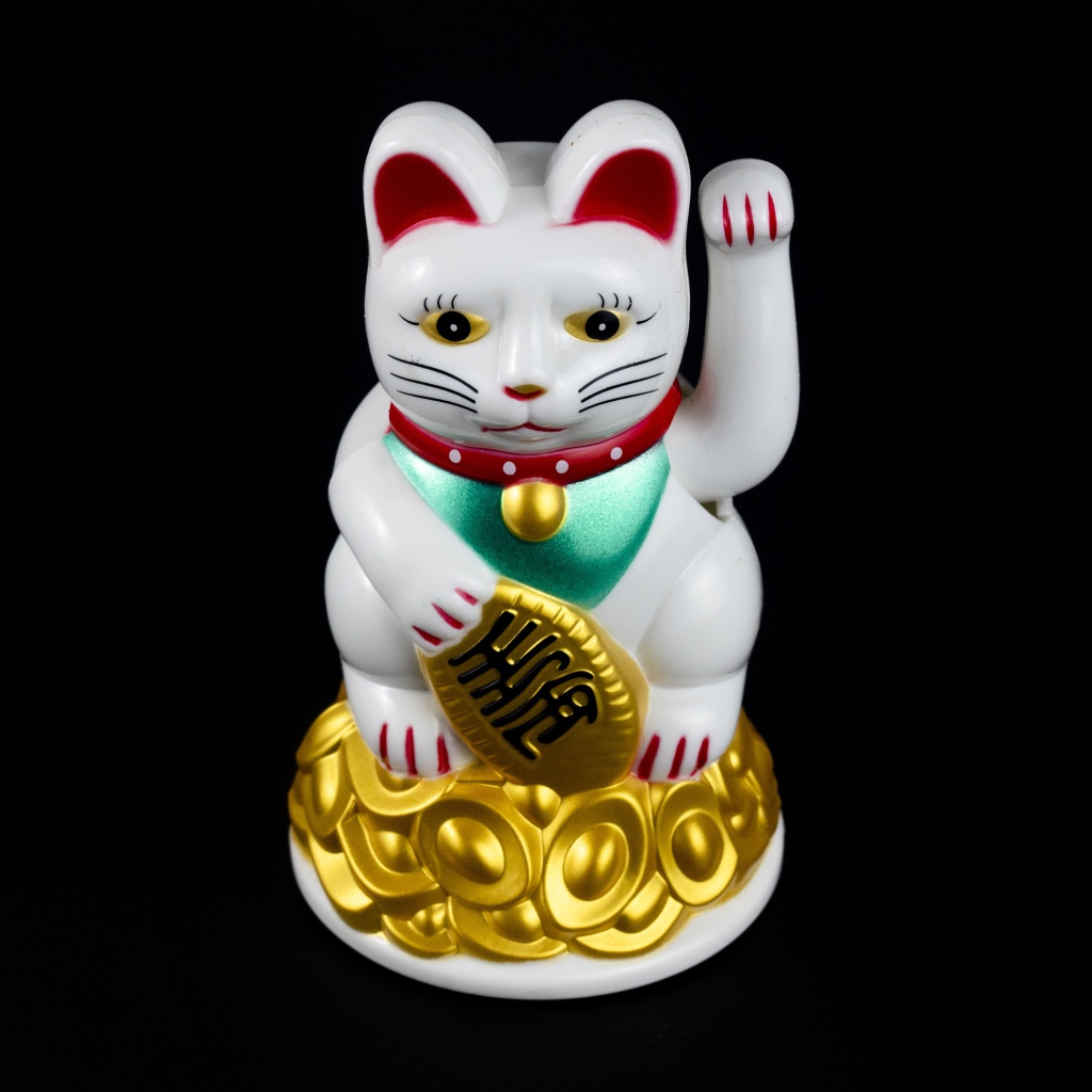 Японская фигурка манэки-нэко кошка на черном фоне