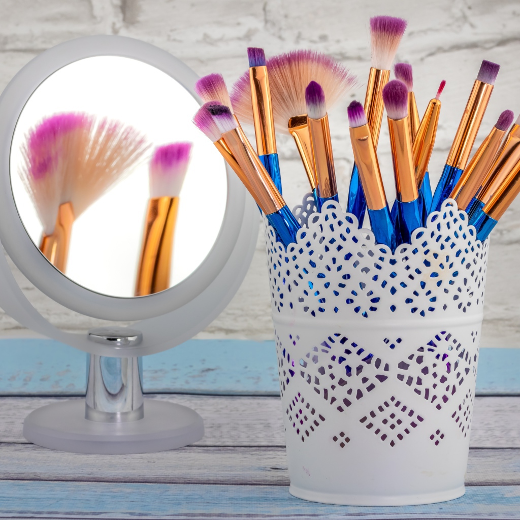 Кисточки для макияжа на столе с зеркалом