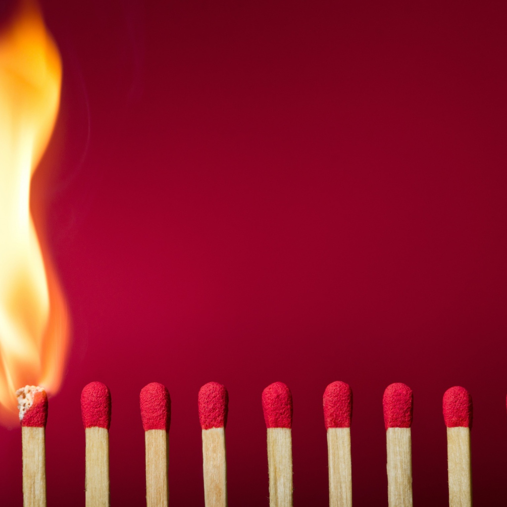 Спички поджигают на красном фоне