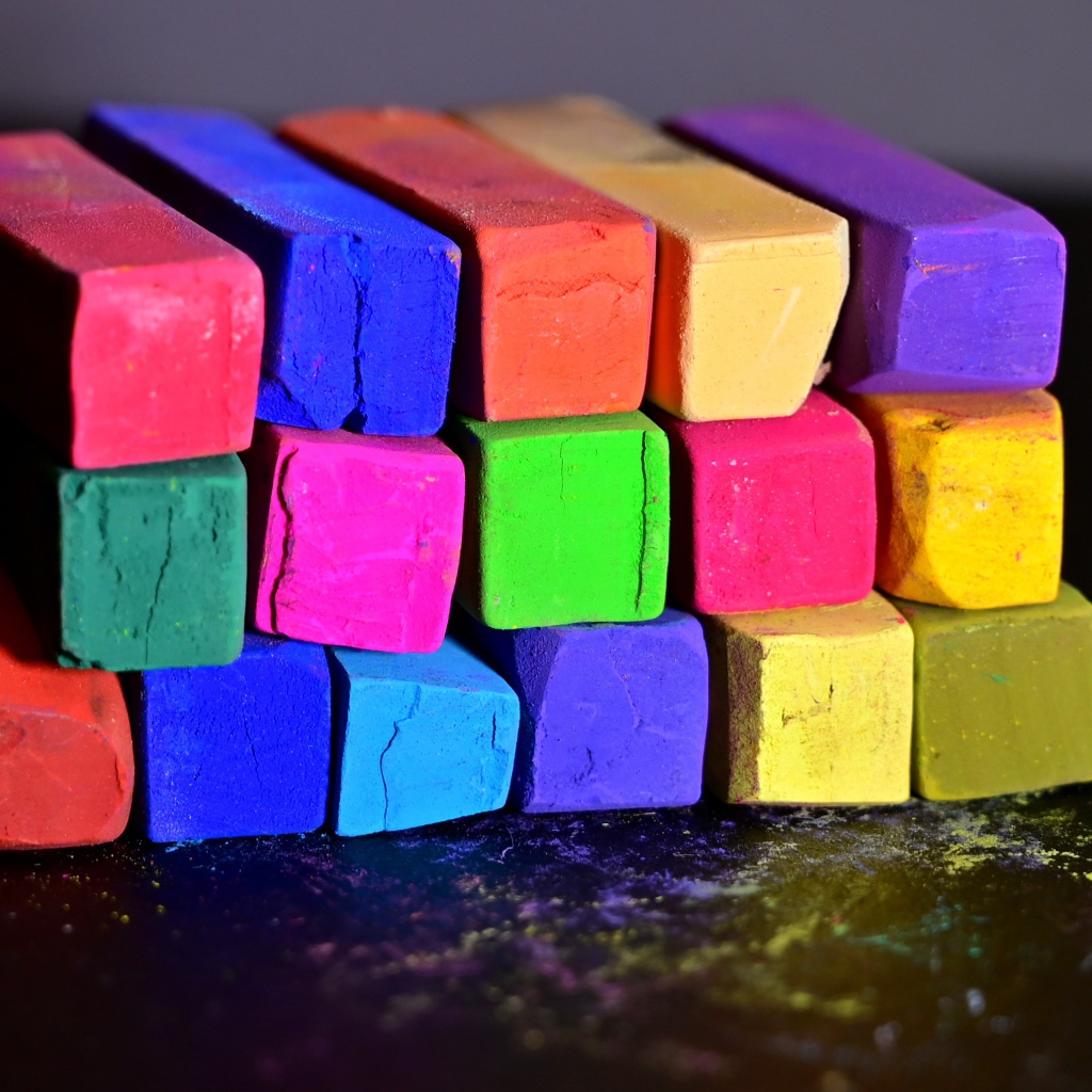 Разноцветные мелки для школы на черной поверхности 