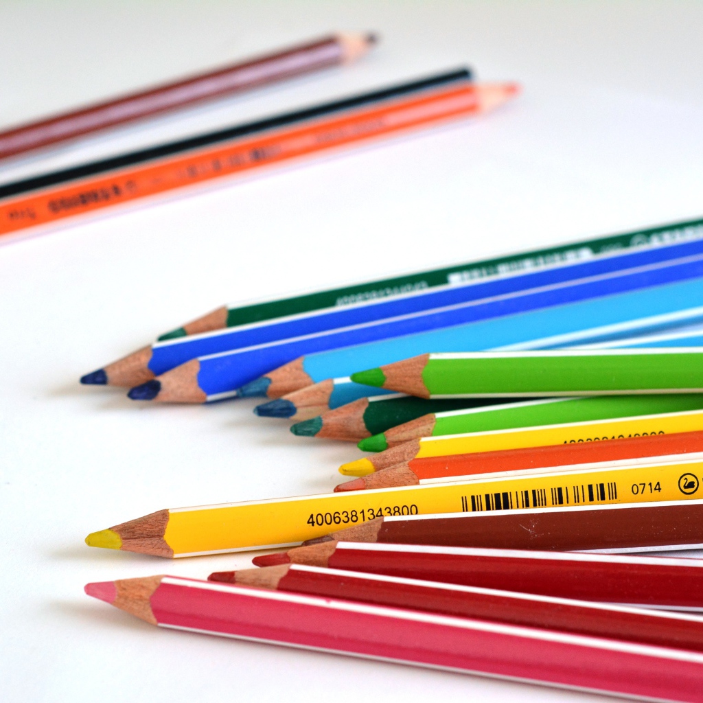 Разноцветные карандаши на белом столе 