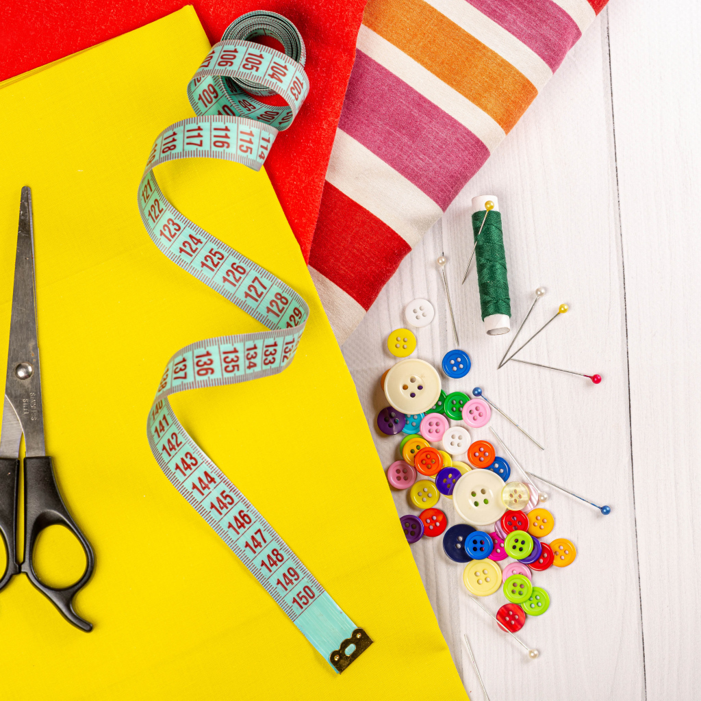 Разноцветная бумага и набор для шитья на столе 