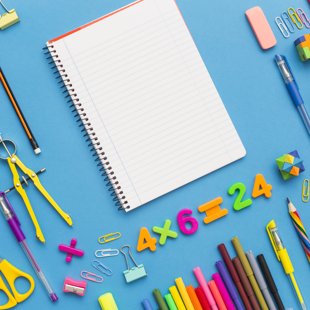 Тетрадь с канцелярскими предметами на голубом фоне 