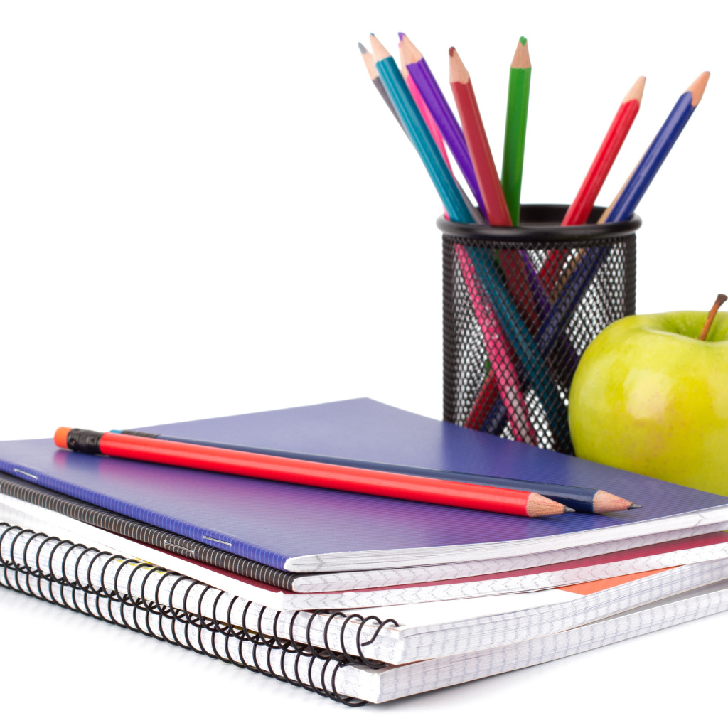 Тетради, яблоко и карандаши на белом фоне 