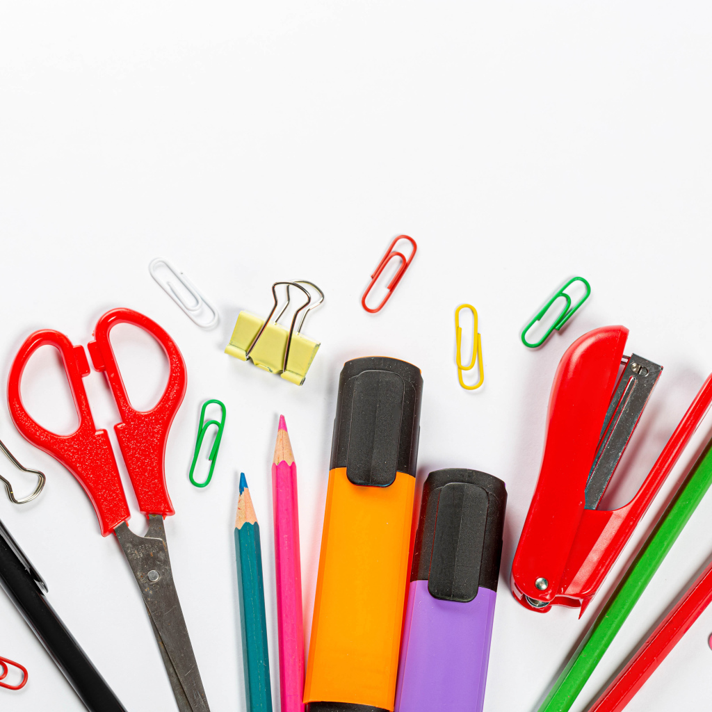 Канцелярские предметы на белом фоне крупным планом 