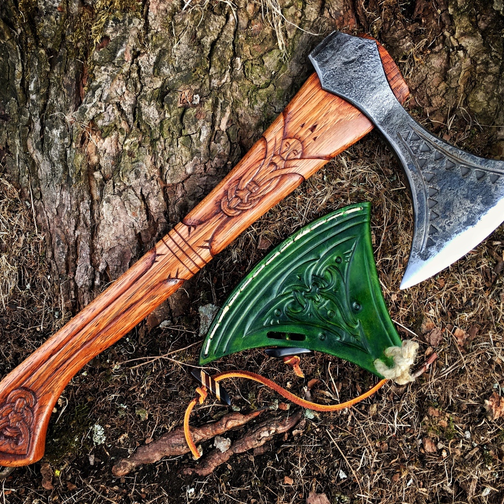 Старый топор с рисунком у дерева 