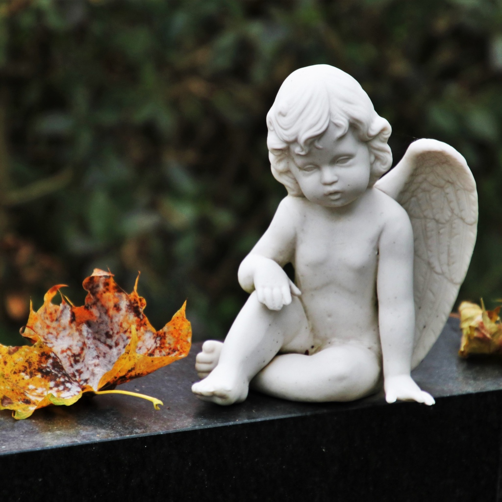 Статуэтка белого ангела с желтыми листьями