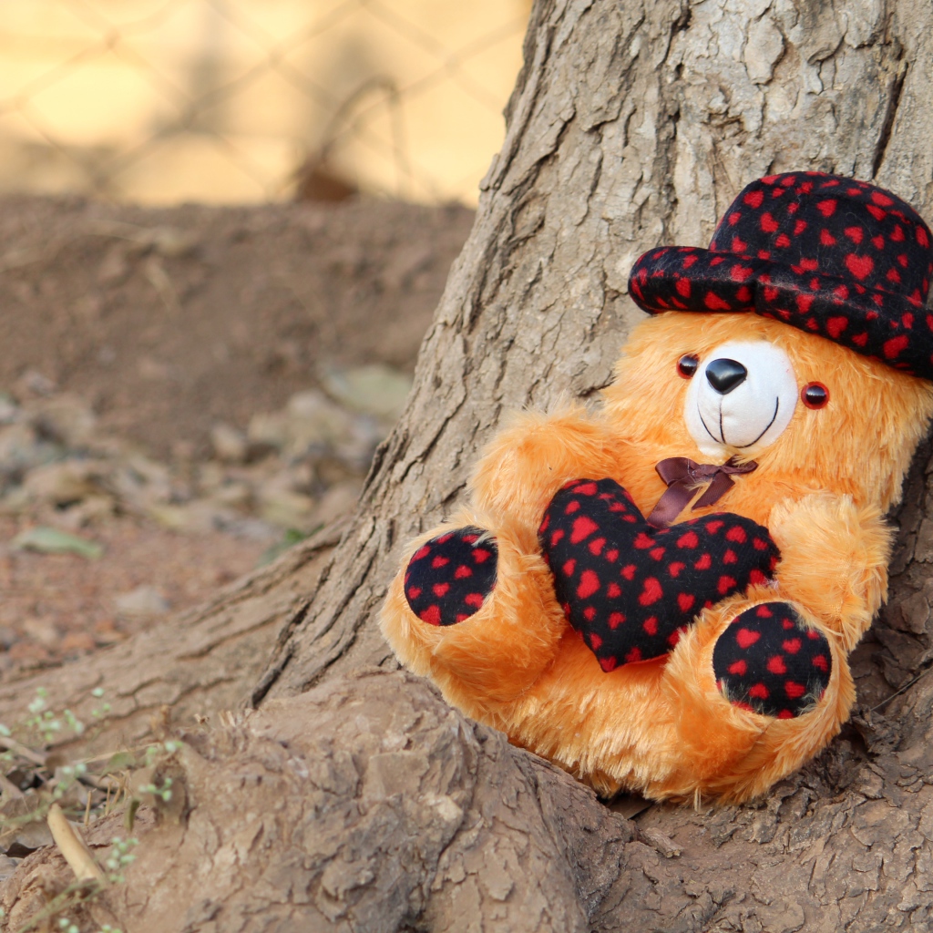 Медвежонок Тедди лежит под деревом