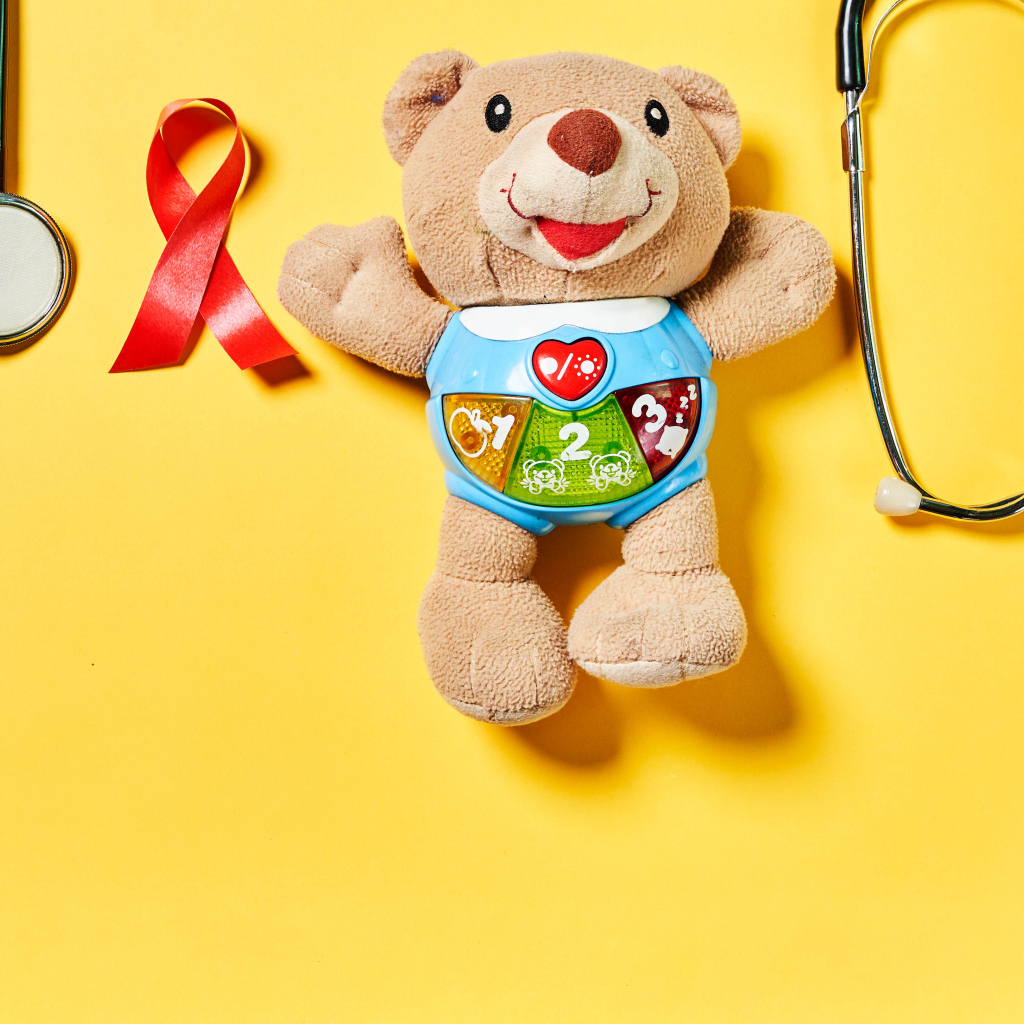 Игрушечный медвежонок с фонендоскопом на желтом фоне 