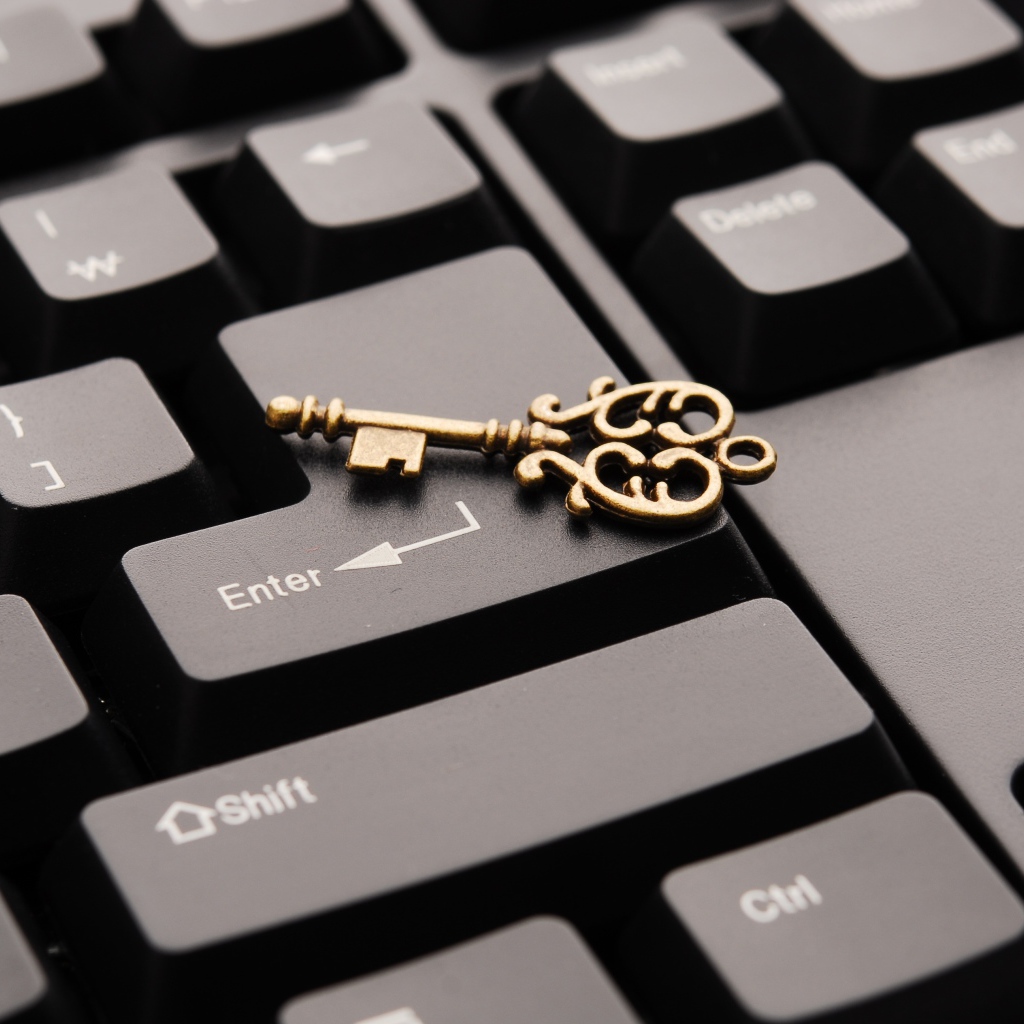 Золотой ключ лежит на черной клавиатуре