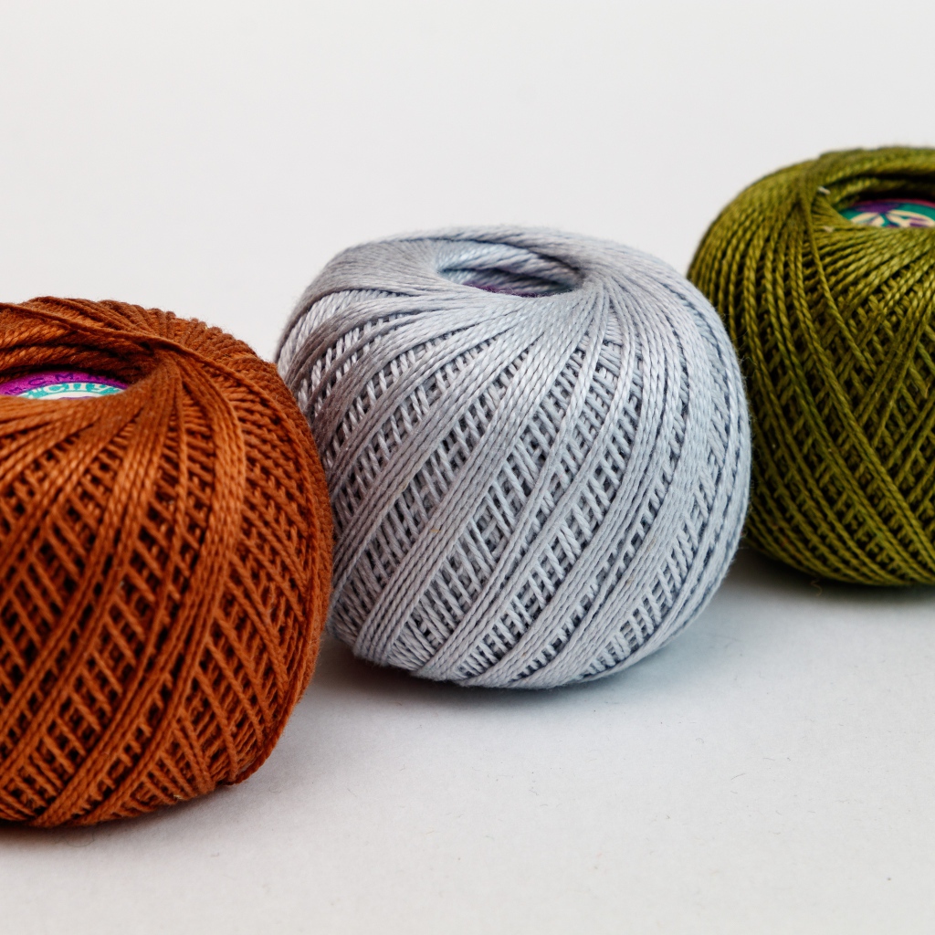 Три клубка пряжи на белом фоне 