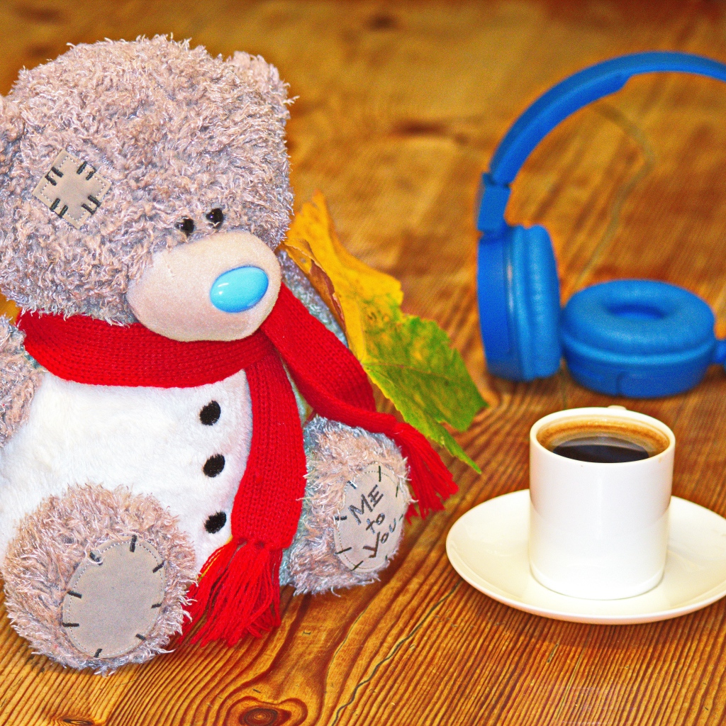 Игрушечный медведь с наушниками и чашкой кофе