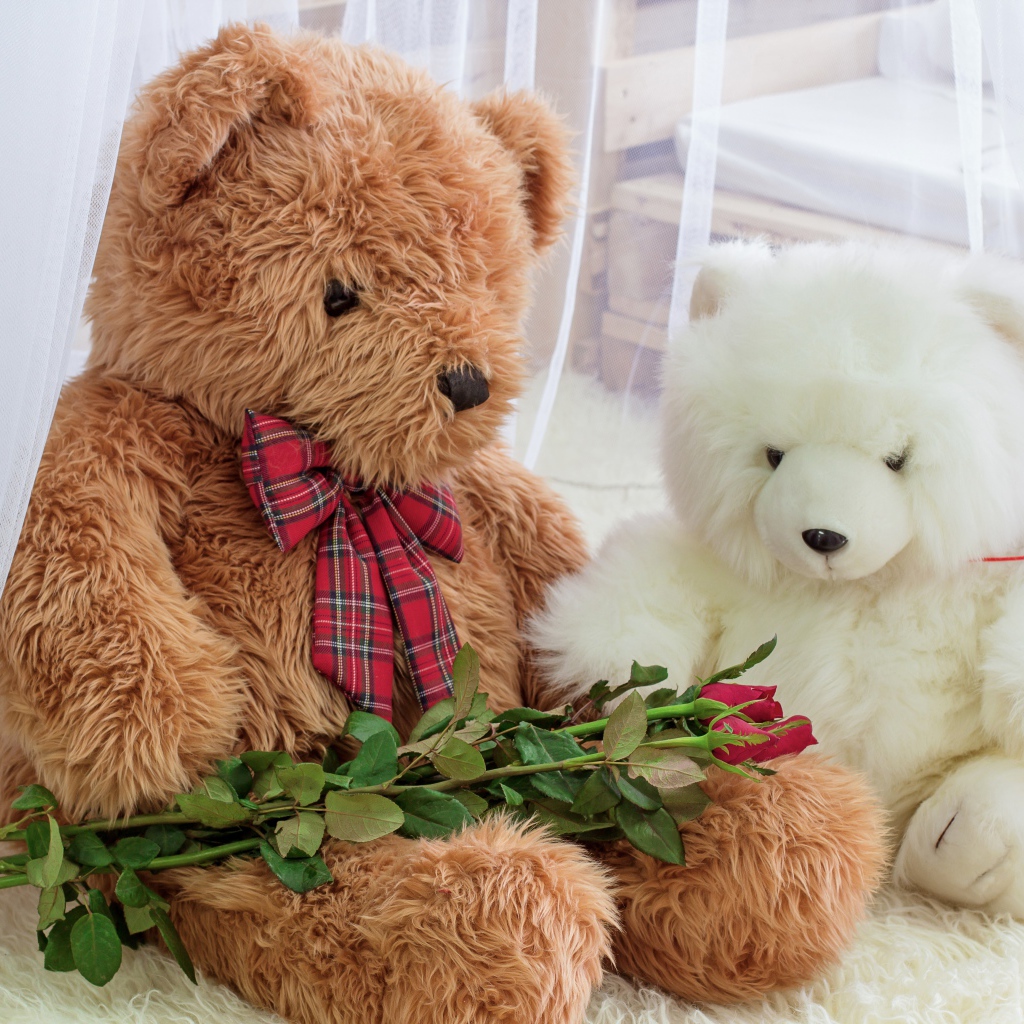 Два больших игрушечных медведя с букетом роз