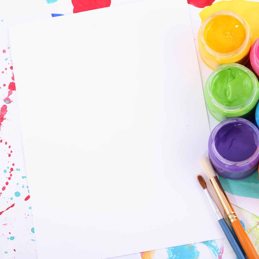 Белый лист бумаги с красками и кисточками