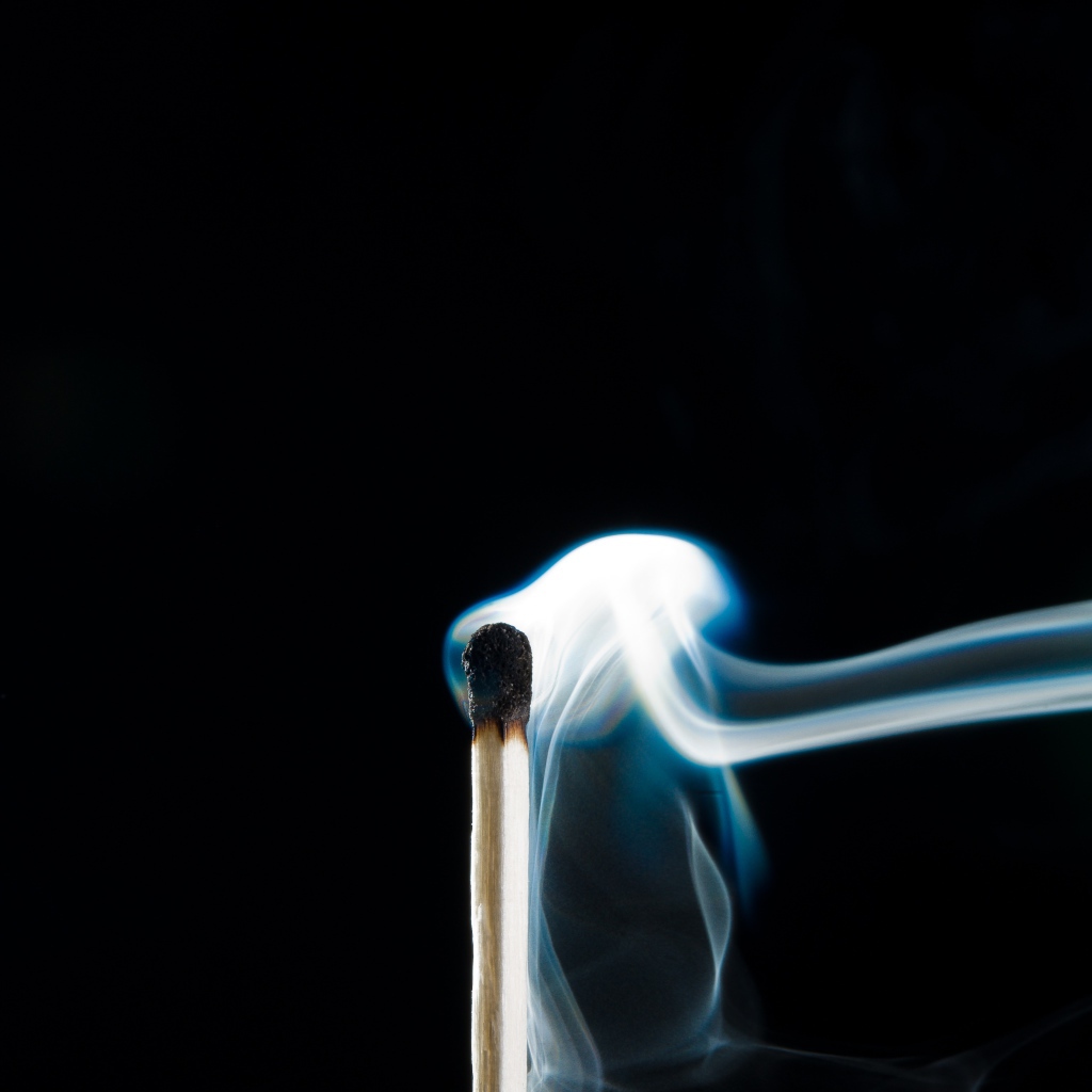 Белый дым от сожженной спички на черном фоне