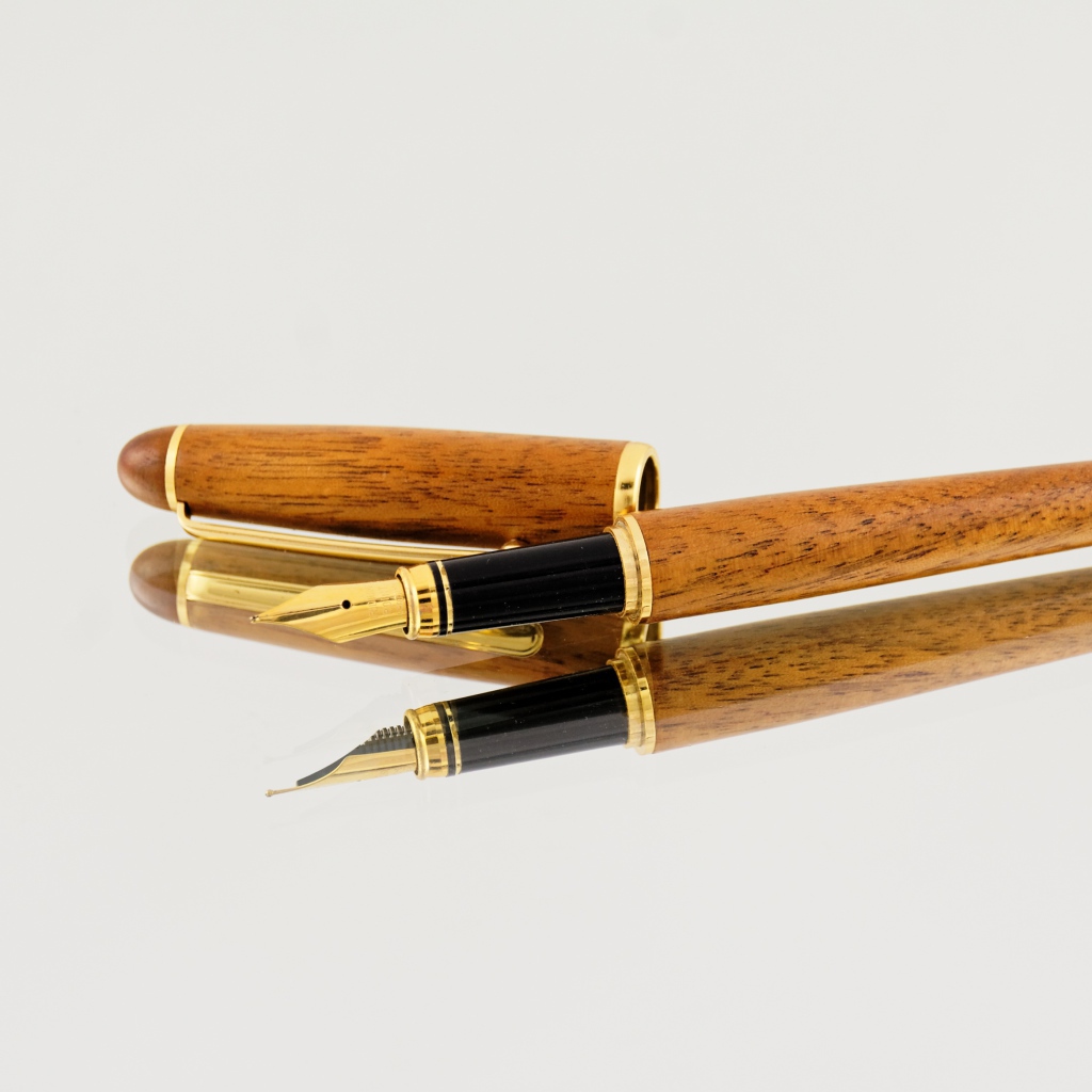 Деревянная ручка перо на сером фоне