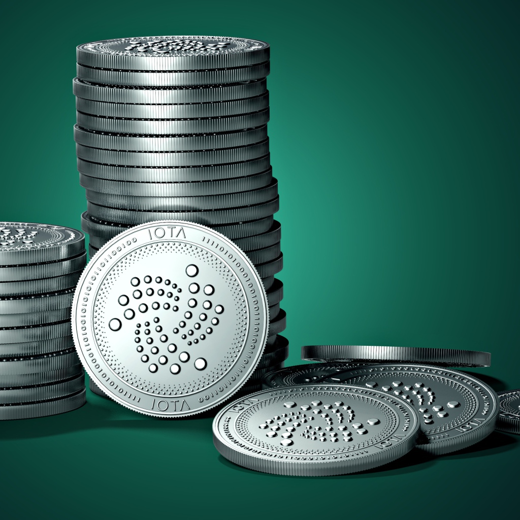 Монеты IOTA на зеленом фоне