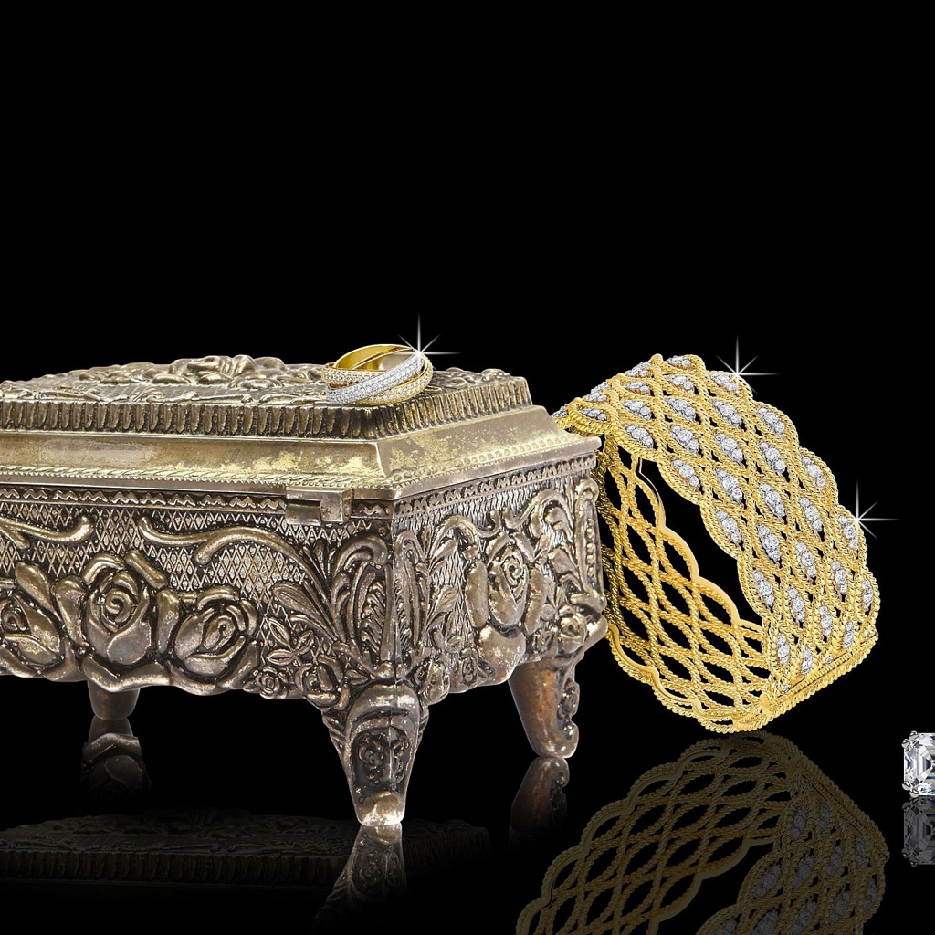 Шкатулка на черном фоне с золотыми украшениями 