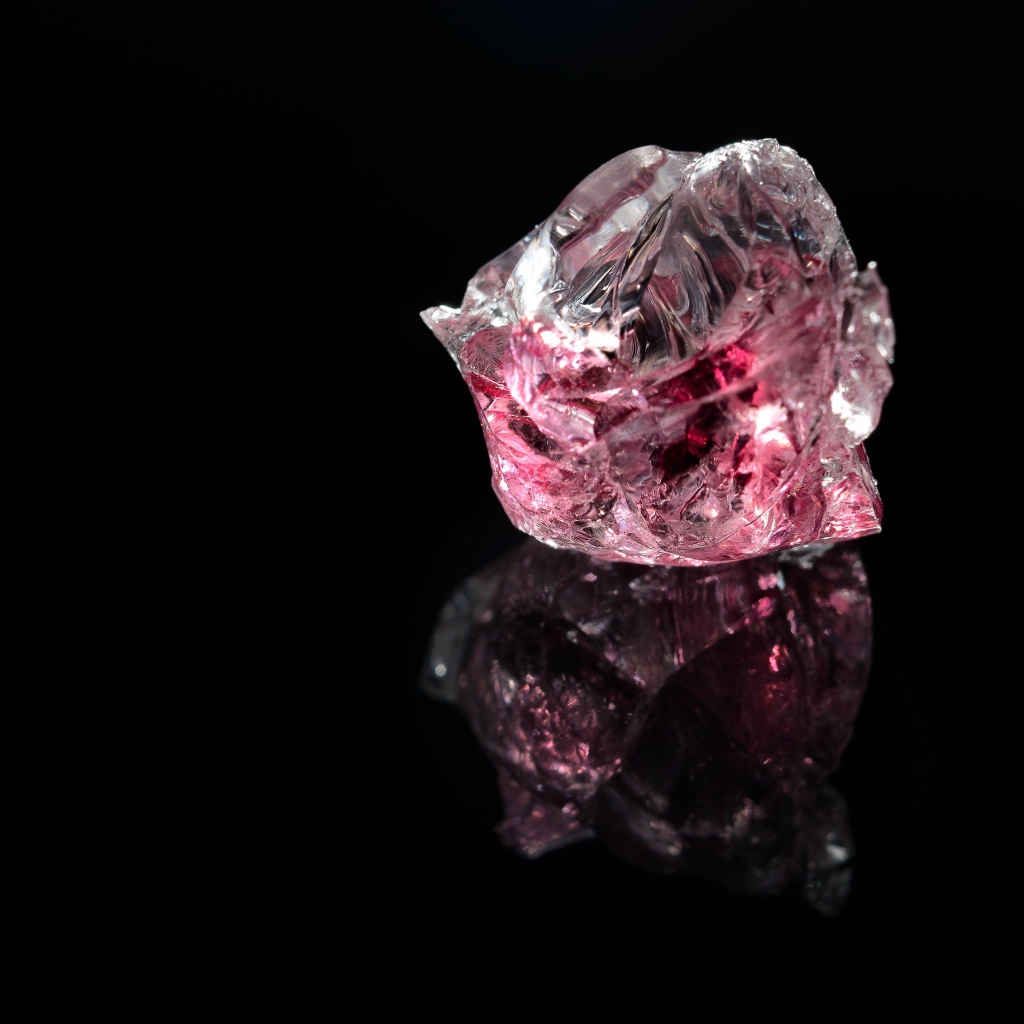 Розовый драгоценный камень на черном фоне 