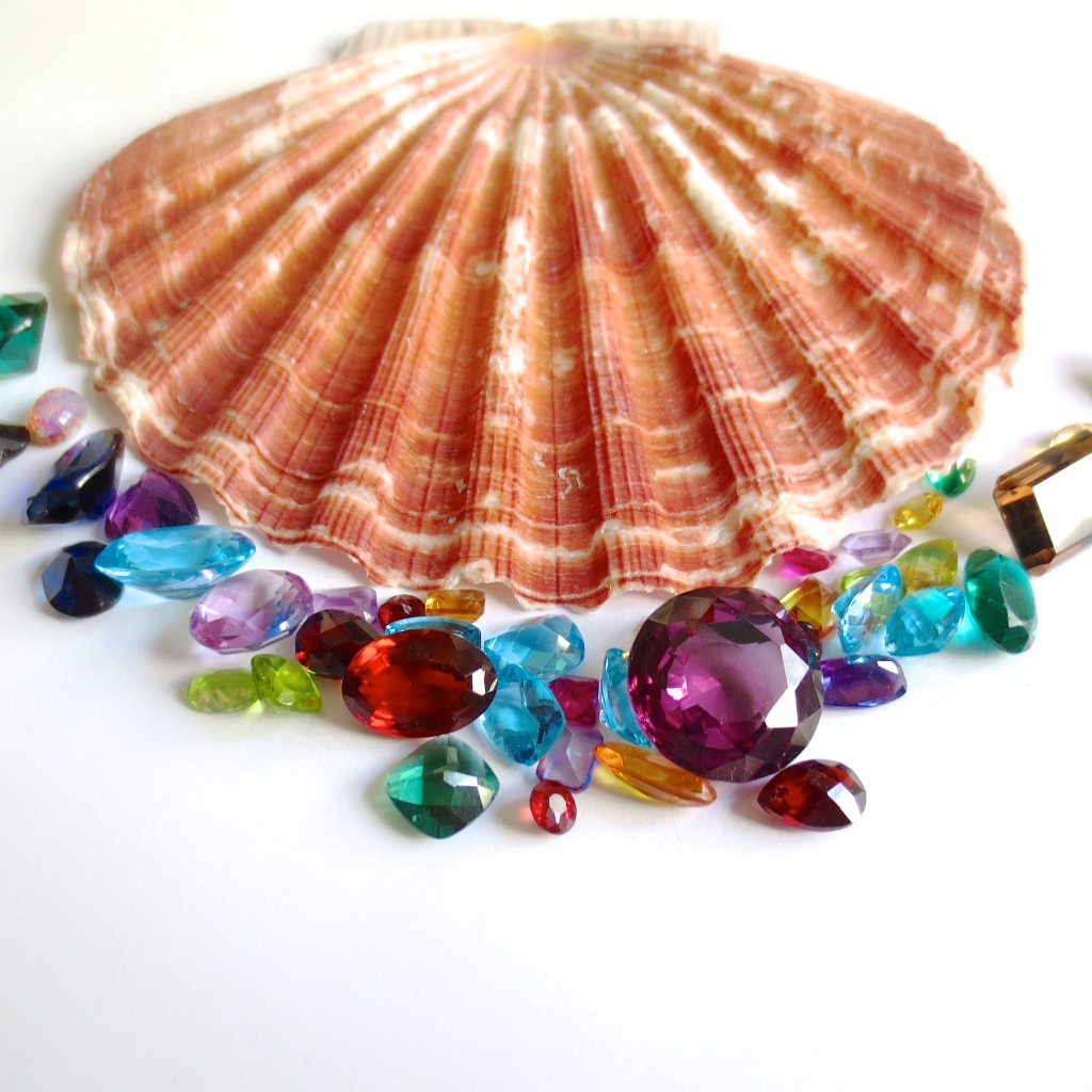 Ракушка и драгоценные камни на белом фоне