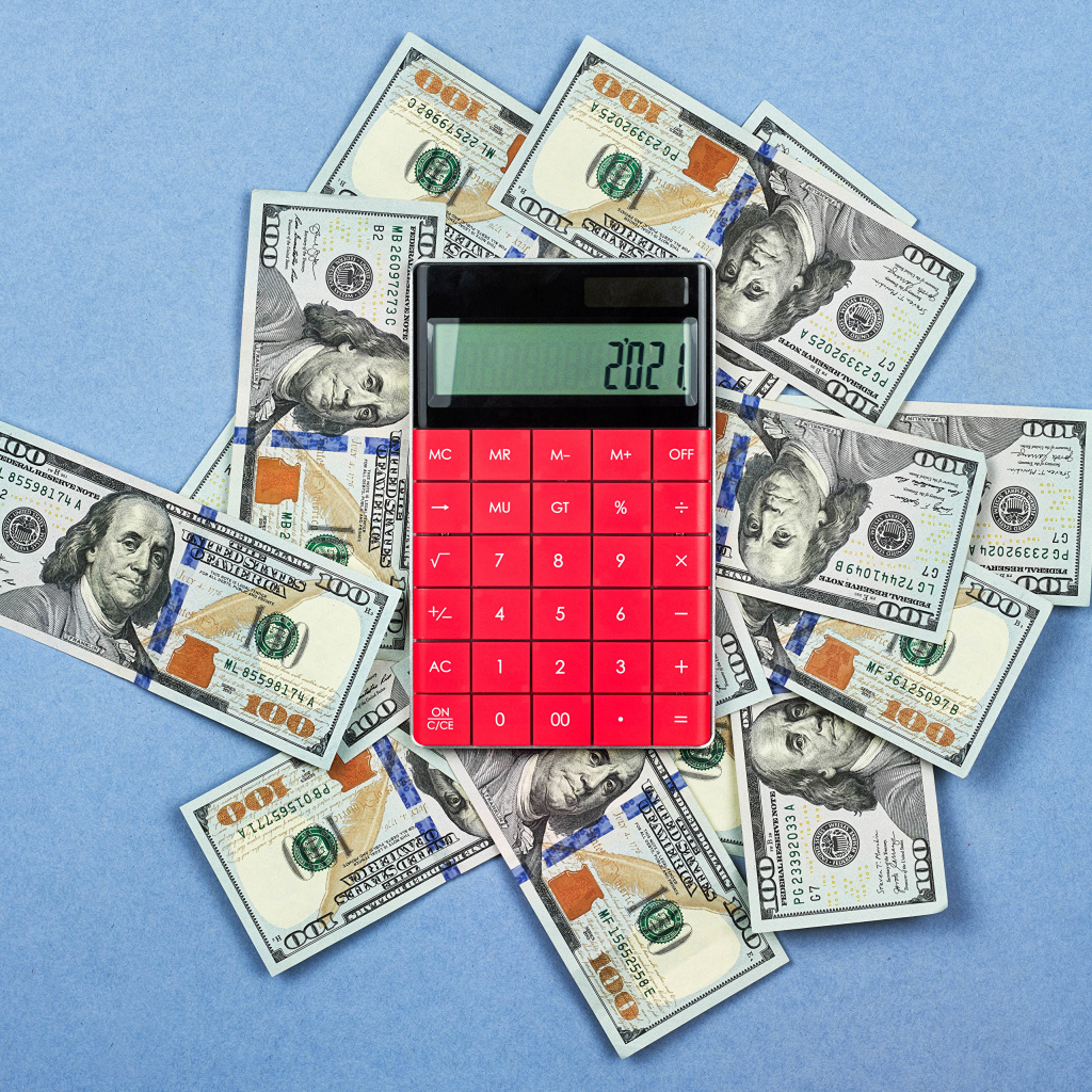 Много долларов с калькулятором на синем фоне